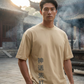 Man wearing a beige t-shirt with Chinese characters in front of traditional architecture